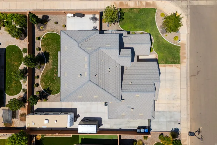 Gray shingle roofing, concrete driveway, concrete patio, front yard landscaping, and backyard landscaping