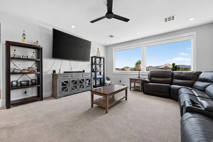 Expansive windows, recessed lighting, ceiling fan, and carpeted flooring
