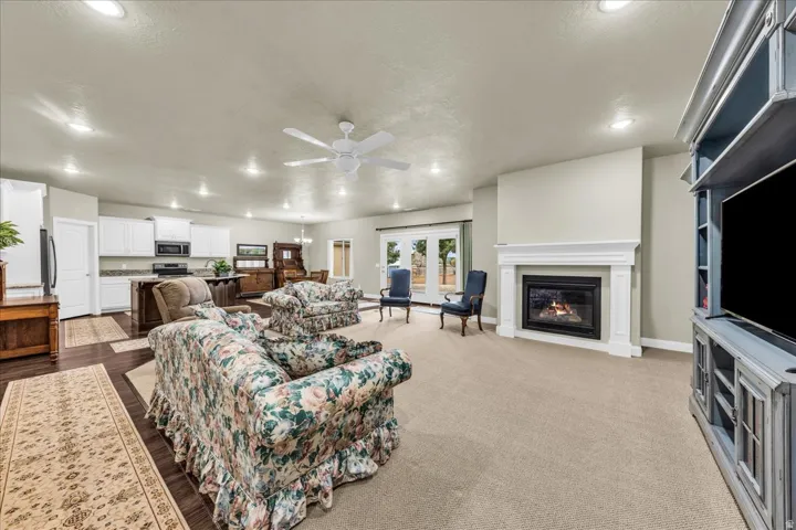 Open-concept living area with a built-in fireplace, recessed lighting, and a ceiling fan