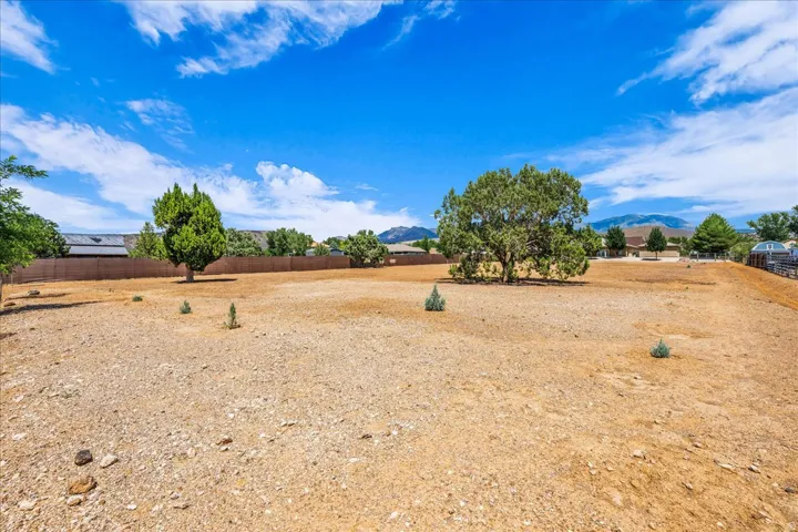 Expansive undeveloped lot featuring mature trees and distant mountain scenery