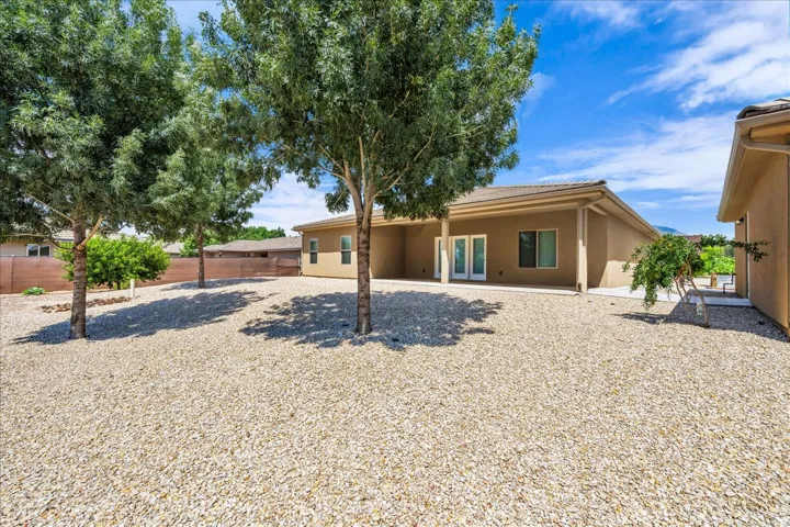 Exterior featuring a stucco finish, covered patio, multiple windows, and dual glass panel doors