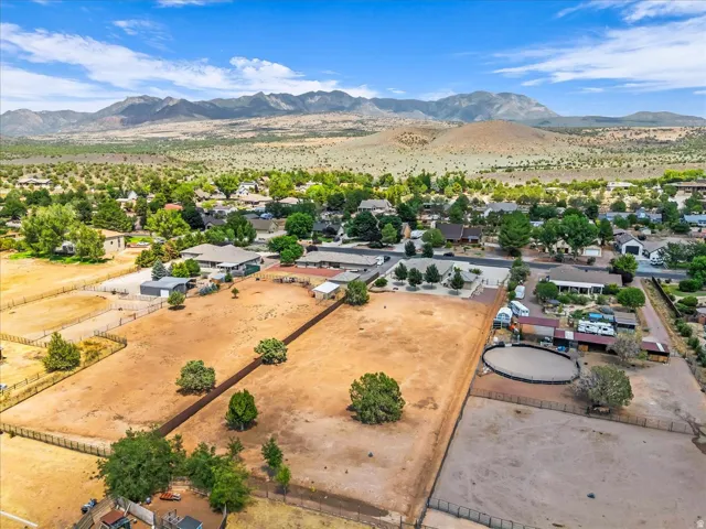 Expansive property featuring multiple fenced areas, a circular riding arena, and mountainous scenery