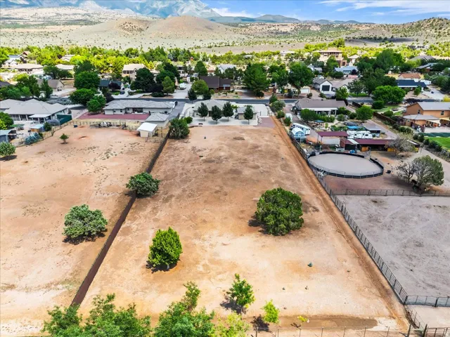 Expansive undeveloped land featuring a perimeter fence and mature trees
