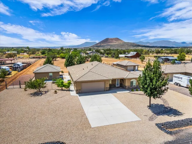 Single-story residence featuring a tile roof, an attached two-car garage, and a concrete driveway