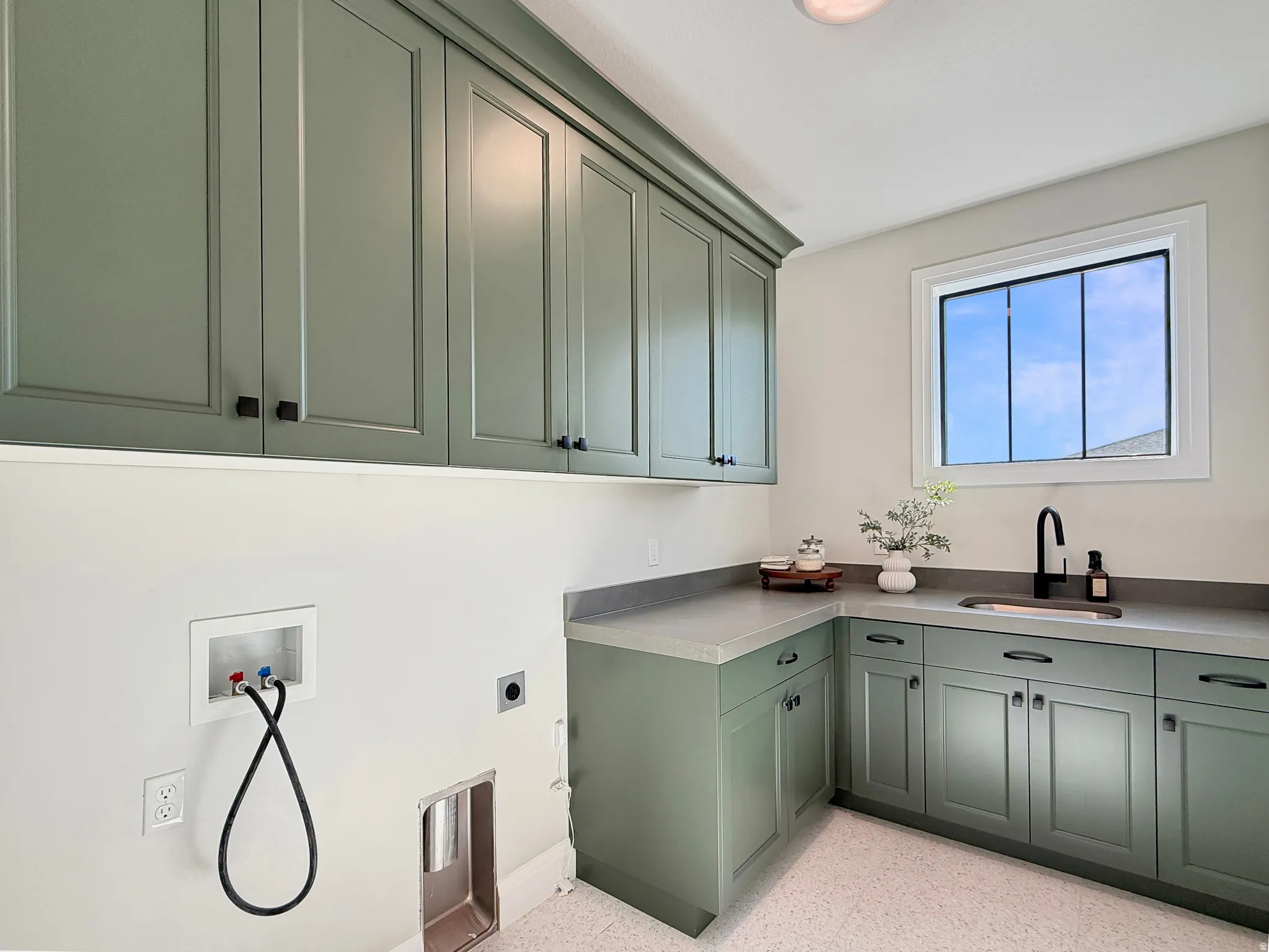 Custom cabinetry with crown molding, solid surface countertops, integrated sink, and a modern black faucet