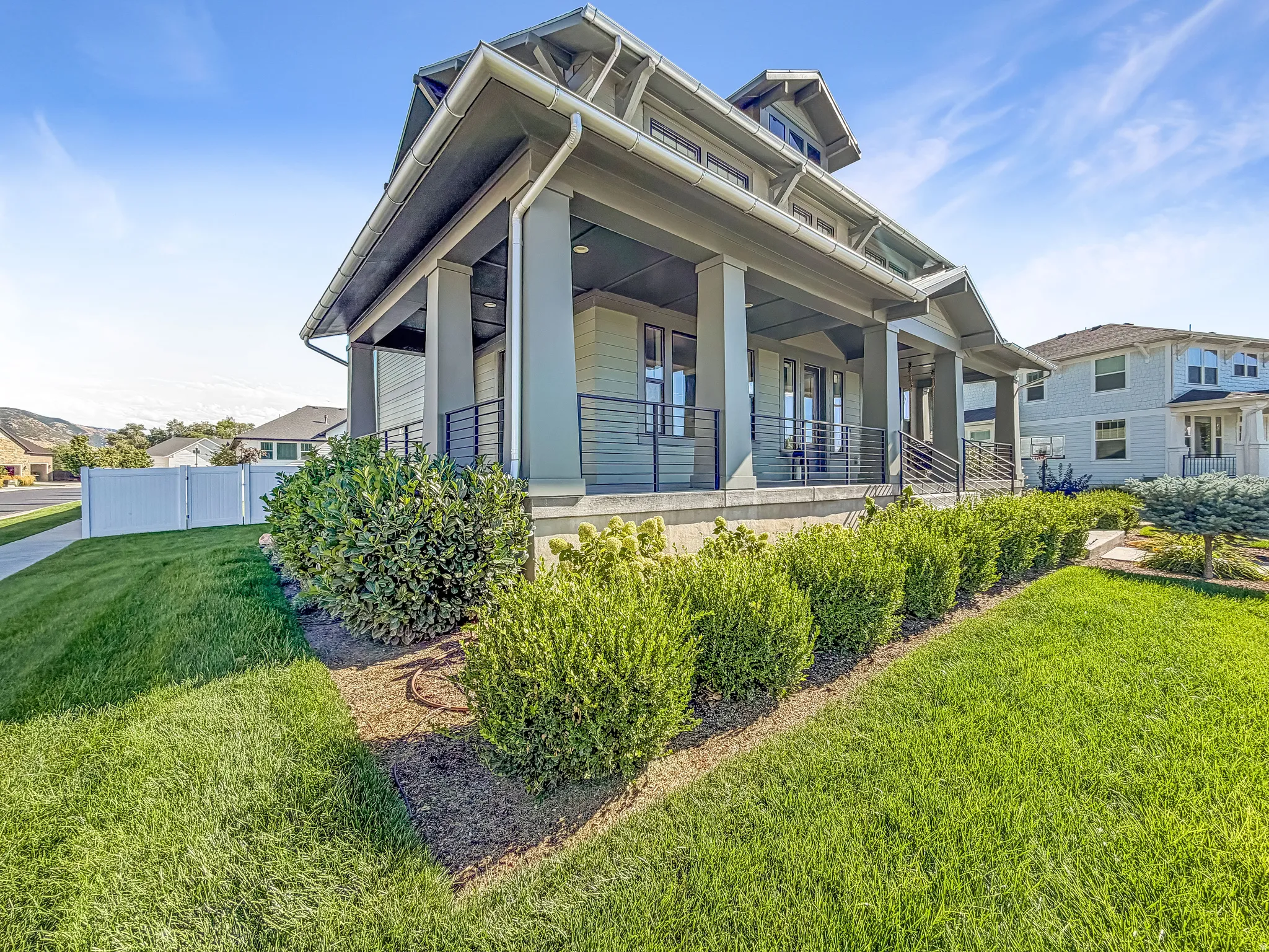Craftsman-style facade with a covered porch, column supports, and horizontal metal railings