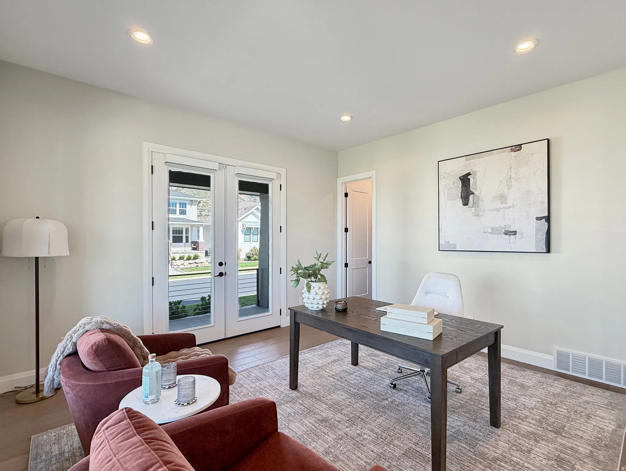Recessed lighting, wood-finish flooring, light-toned wall paint, white trim, and white French doors