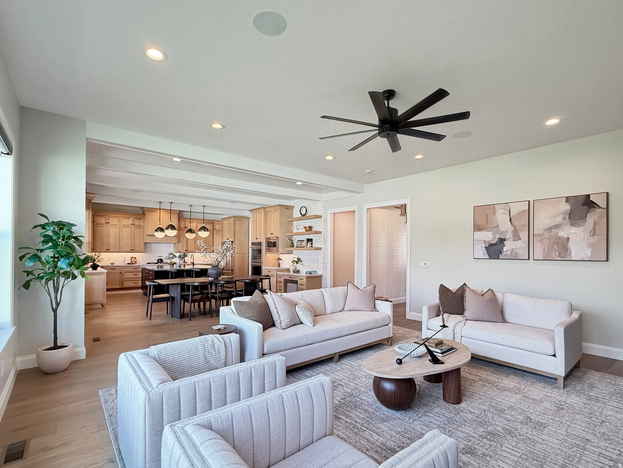 Open-concept living area with wood-finish flooring, recessed lighting, and a contemporary ceiling fan