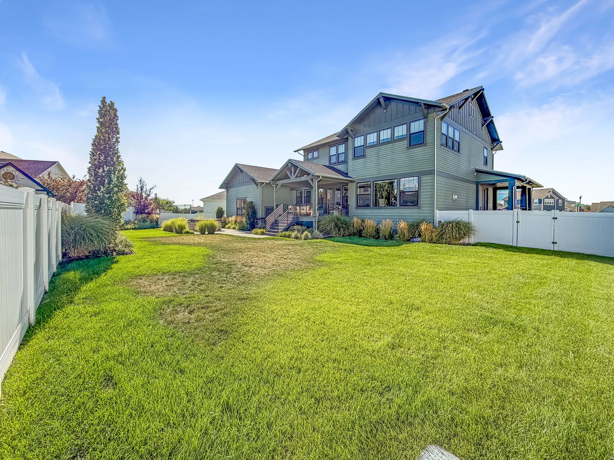 Expansive lawn area with a white privacy fence