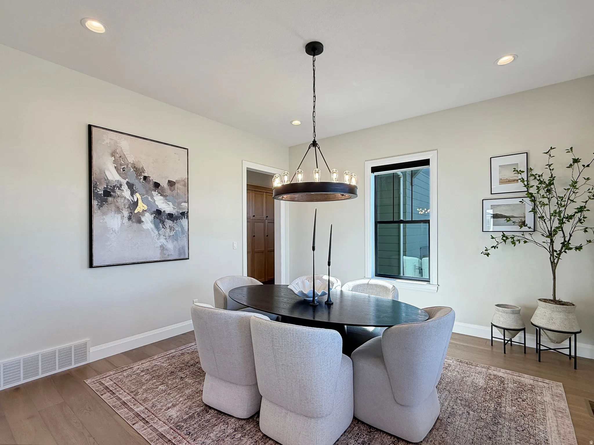 Recessed lighting, wood-finish flooring, and a contemporary chandelier