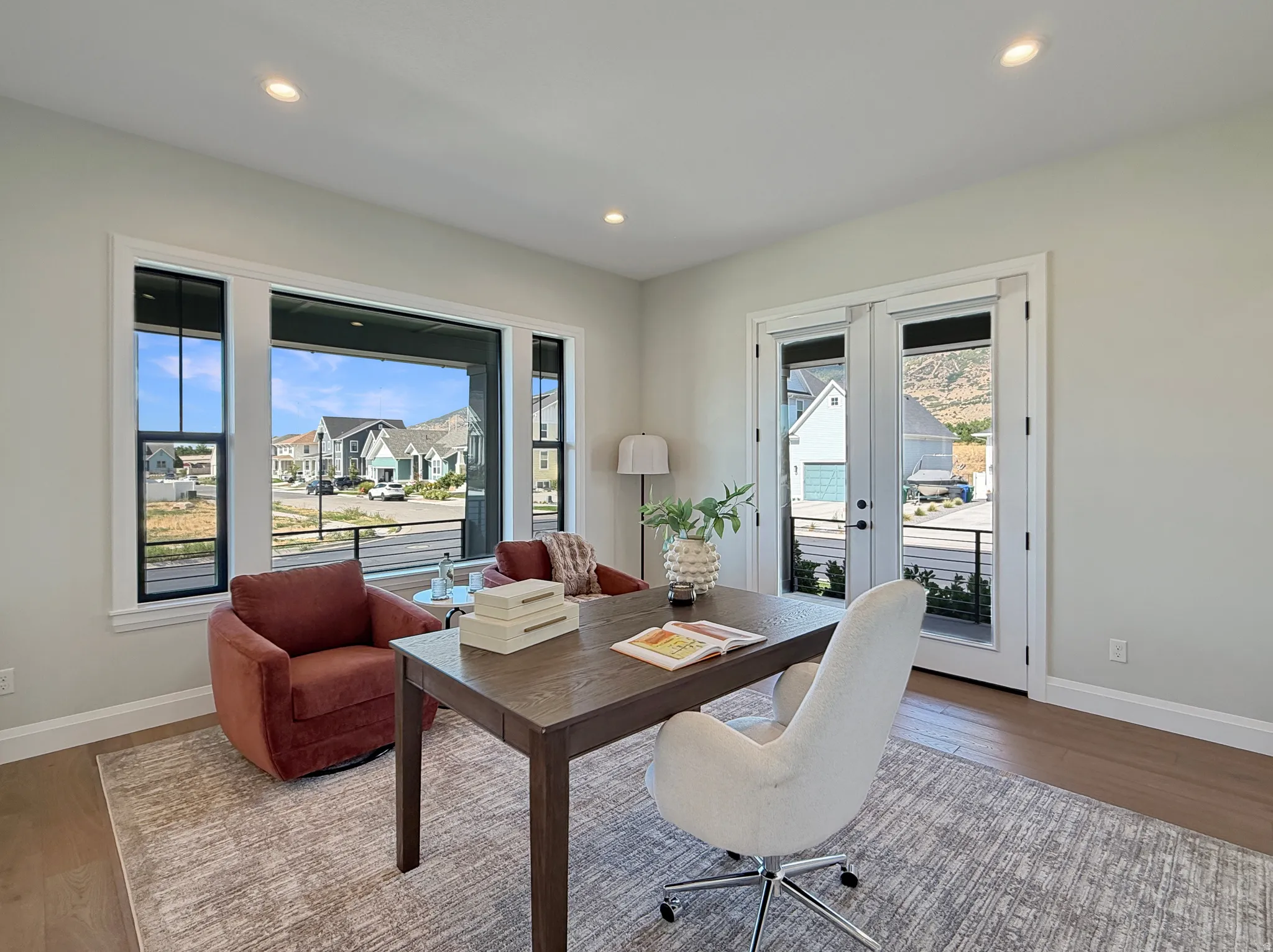 Recessed lighting, wood-finish flooring, white trim, French doors, and large windows with black frames