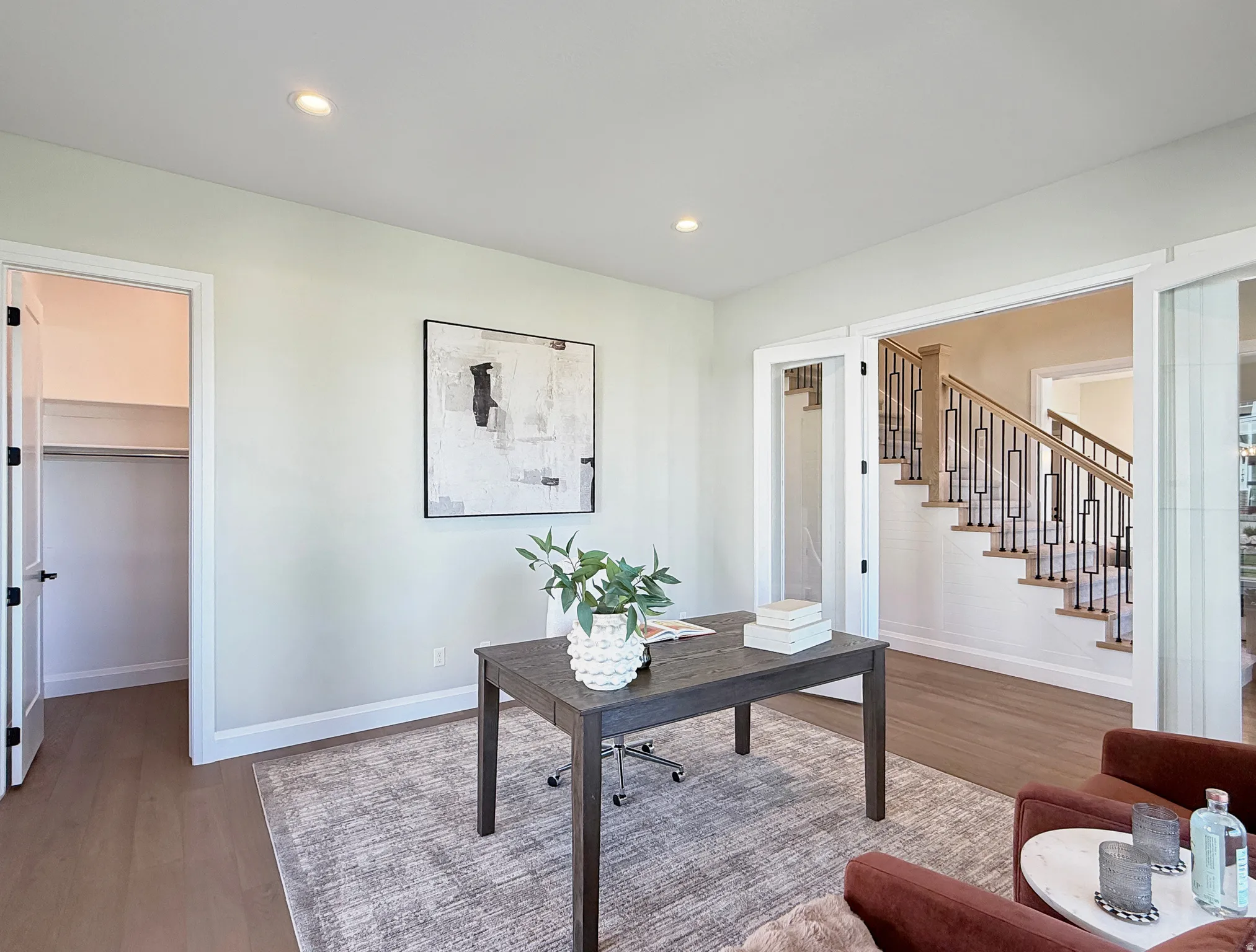 Recessed ceiling lighting, durable wood-finish flooring, and a closet with a built-in hanging rod