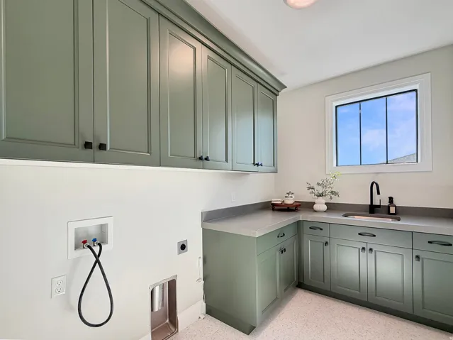 Custom cabinetry with crown molding, solid surface countertops, integrated sink, and a modern black faucet
