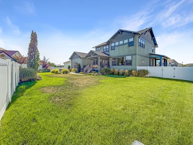 Expansive lawn area with a white privacy fence