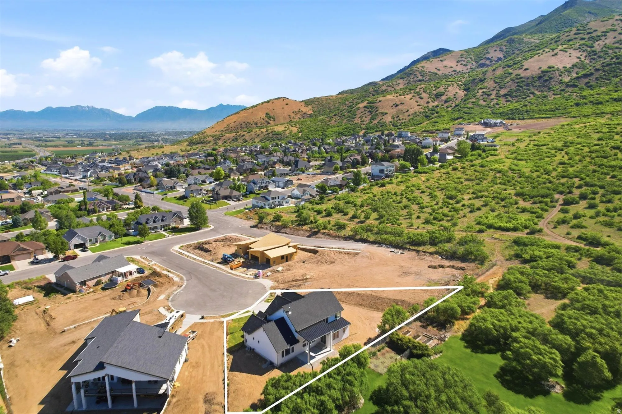 Property featuring a new construction residence with an attached garage, set on a graded lot with mountain scenery