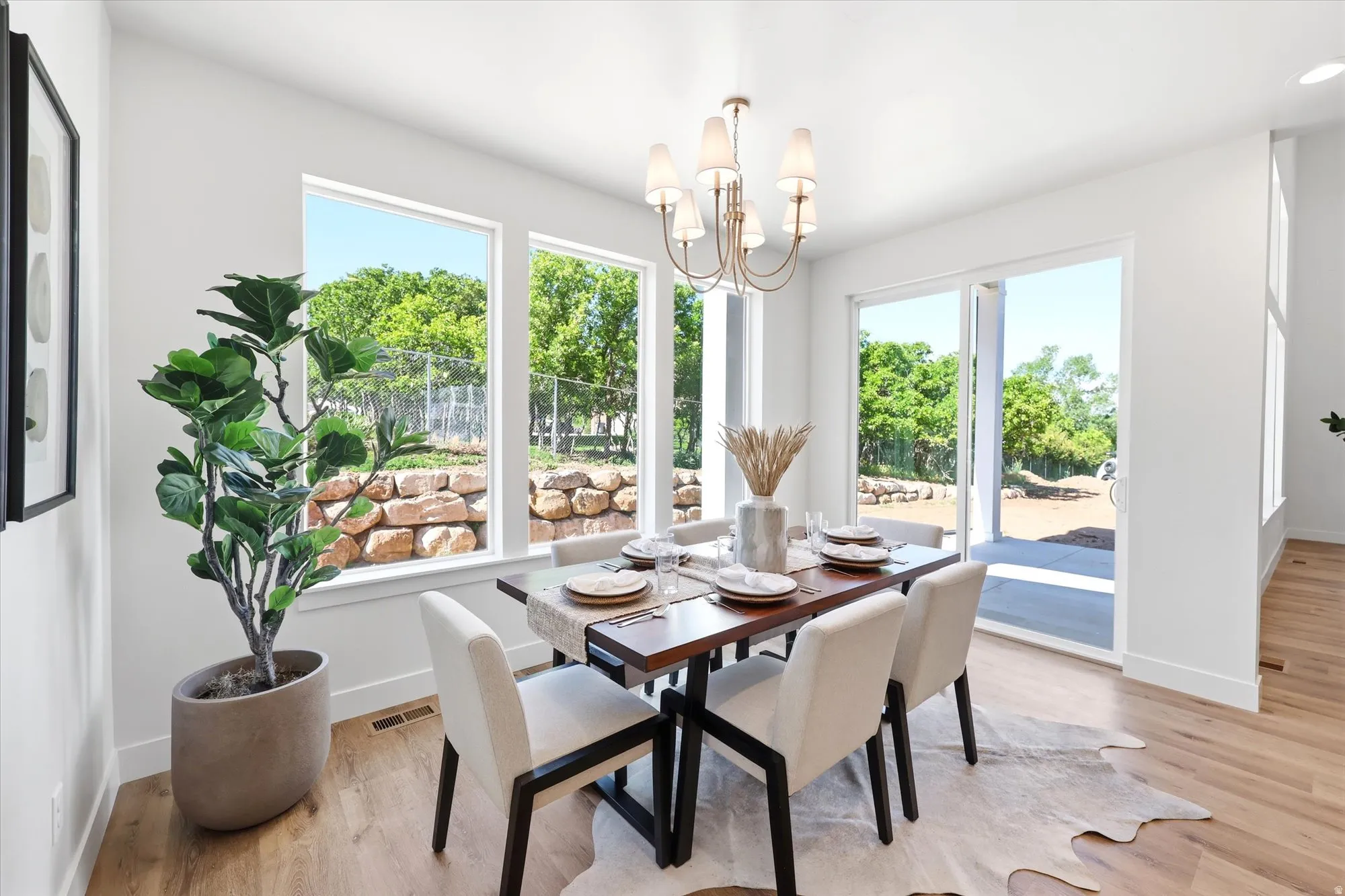 Hardwood-finish flooring, multiple large windows, and a sliding glass door provide natural light