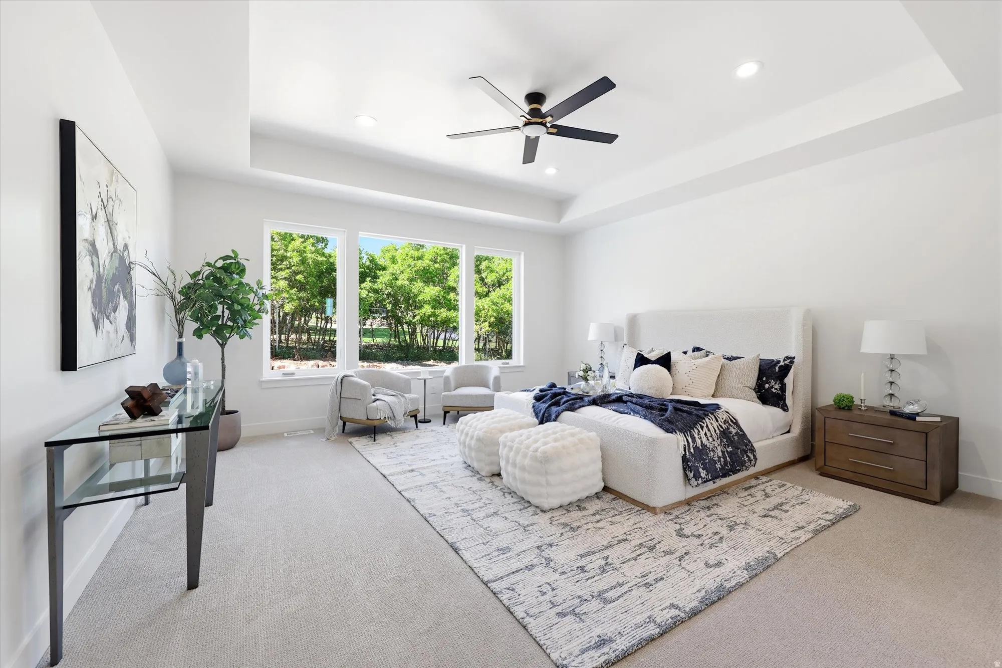 Recessed lighting, ceiling fan, tray ceiling, triple pane windows, and light-colored carpeting