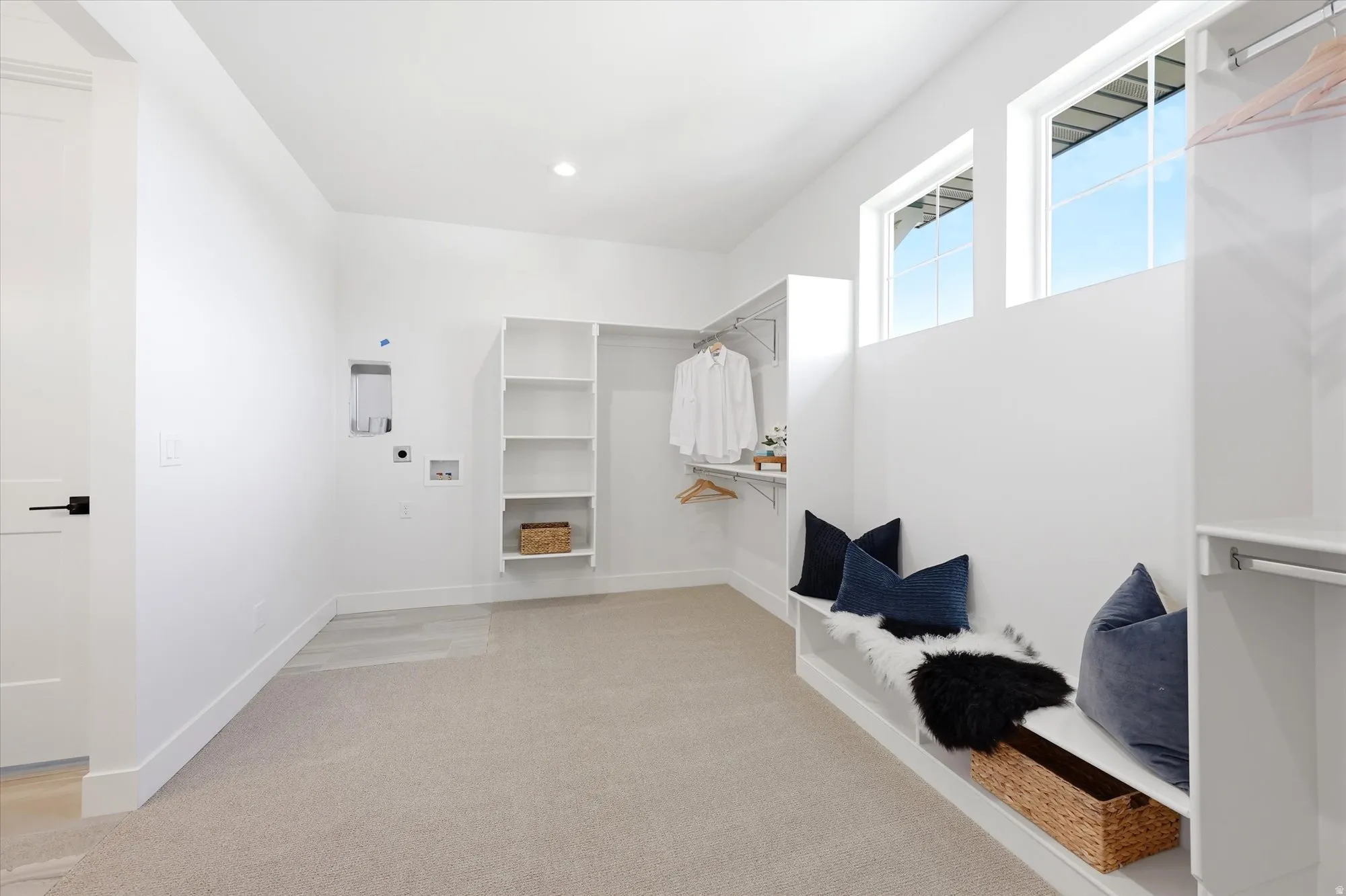 Recessed lighting, built-in shelving, hanging closet rods, two transom windows, and light-colored carpeting