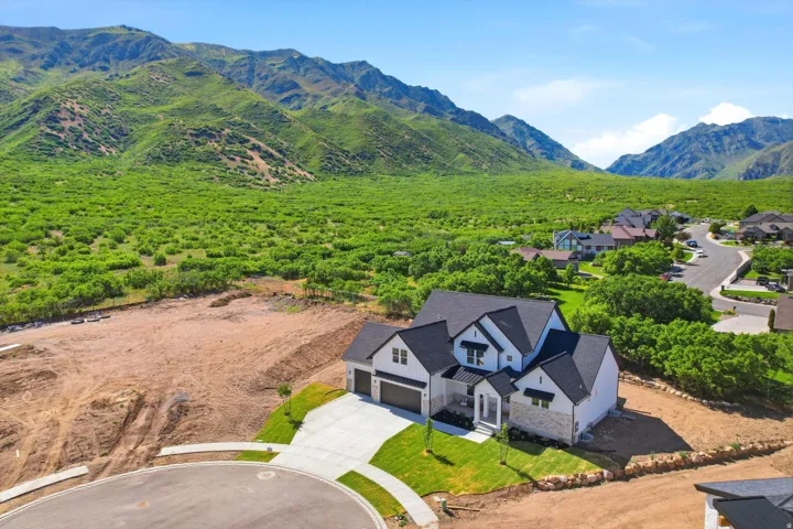 New construction residence with a multi-gabled roofline, stone and siding exterior, two-car garage, and a concrete driveway