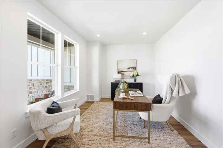 Recessed lighting, wood-finish flooring, and white walls create a bright interior