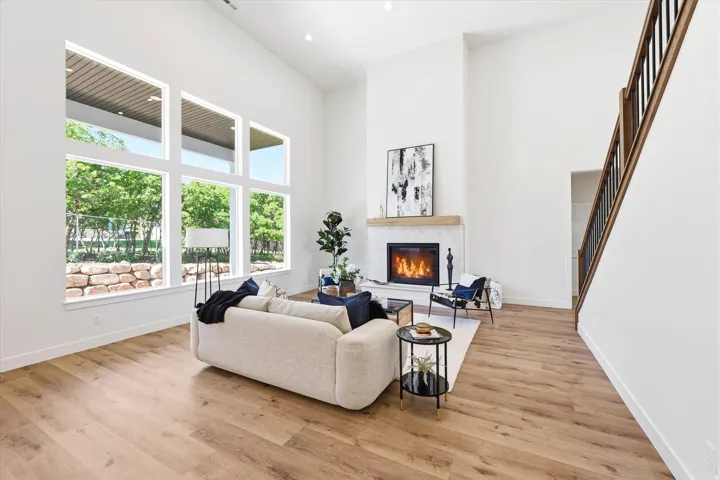 Vaulted ceilings, a full-height fireplace, and wood-finish flooring define this living space