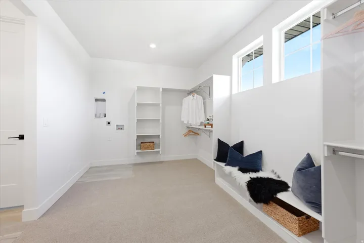 Recessed lighting, built-in shelving, hanging closet rods, two transom windows, and light-colored carpeting