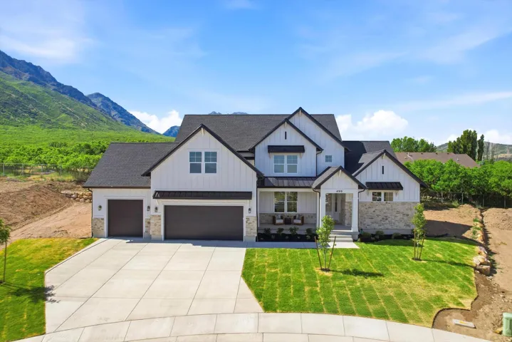 Modern farmhouse exterior with white board and batten siding, stone accents, and a dark shingle roof
