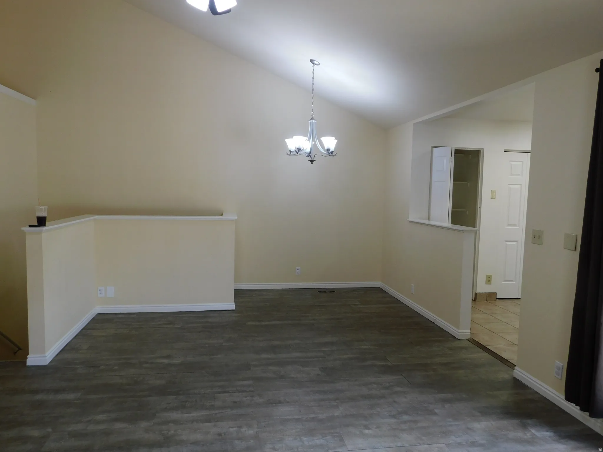 Vaulted ceilings, wood-finish flooring, and a contemporary chandelier