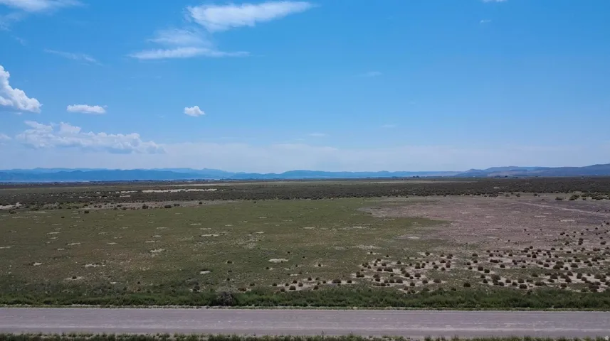 Expansive open terrain featuring natural vegetation and distant mountain ranges
