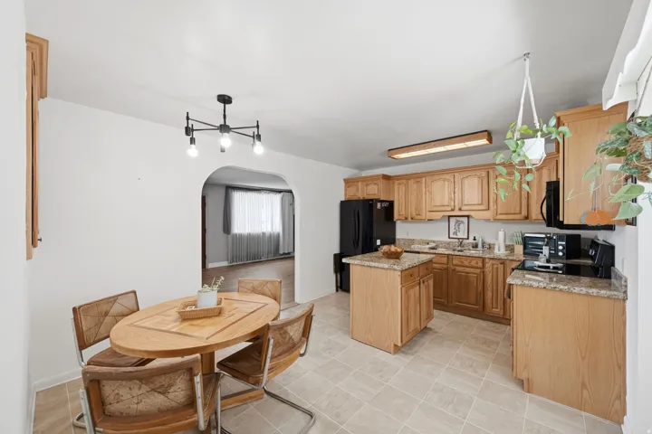 Kitchen featuring wood cabinetry, light-toned countertops, and a central island