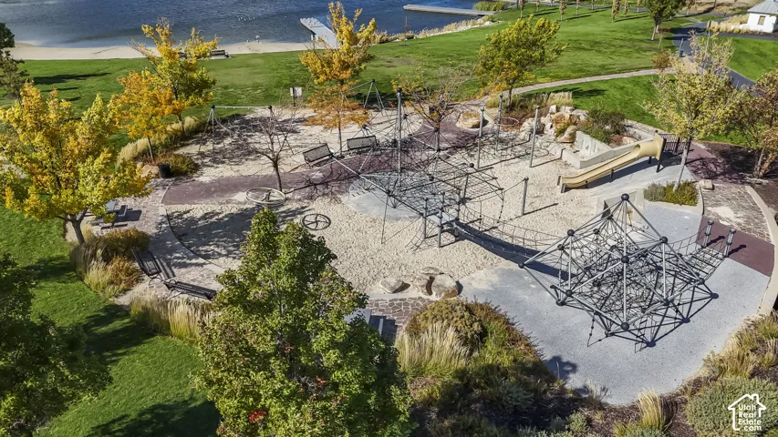 Recreational area featuring multiple play structures, sand surfacing, a slide, and swings