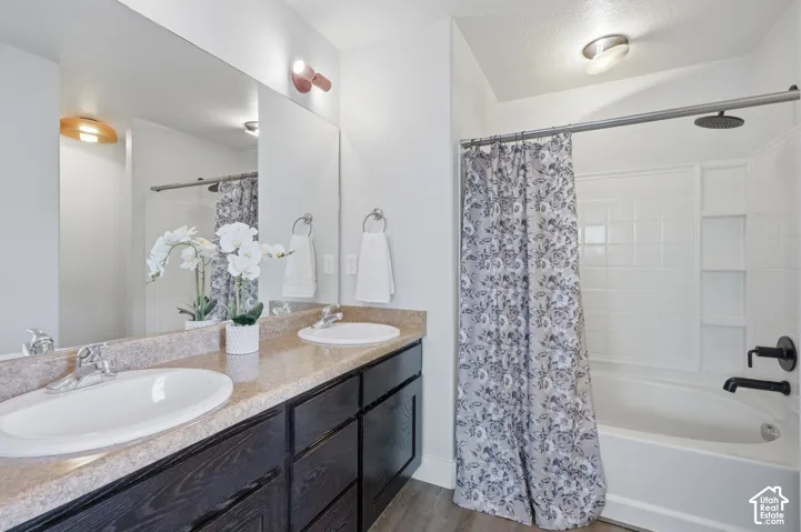 Dual vanity with white oval sinks, dark wood-finish cabinetry, and a textured countertop