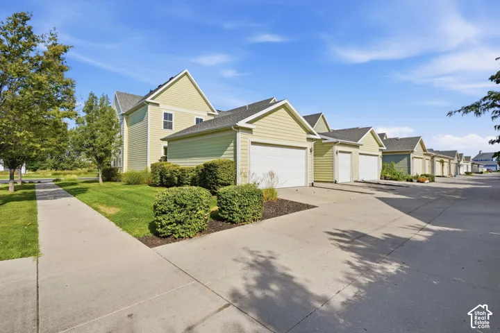 Multiple garages with light green siding and white garage doors