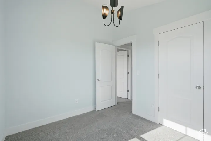 Light-toned walls, grey carpeting, and white paneled doors