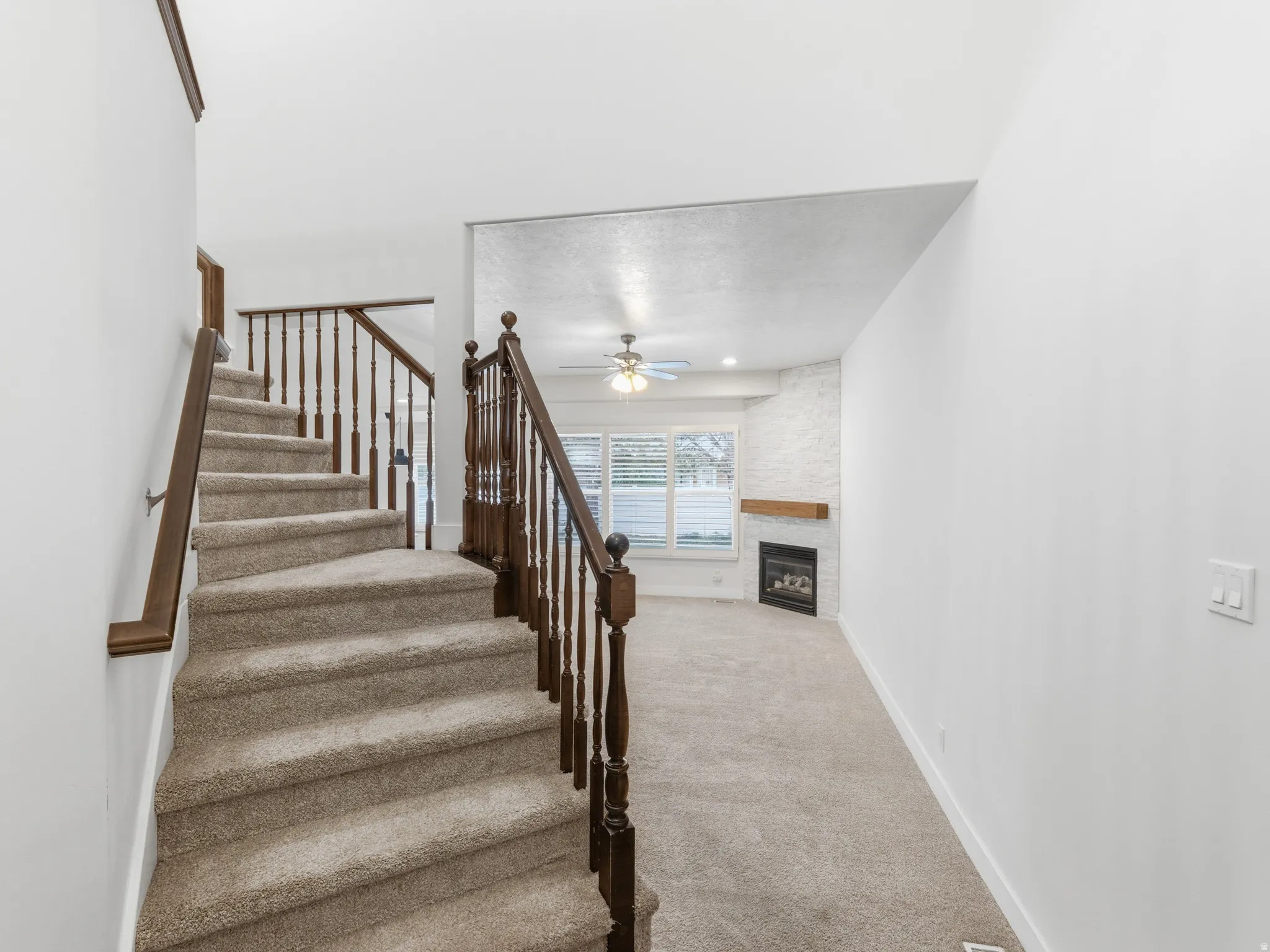 Carpeted staircase with wood banister and spindles