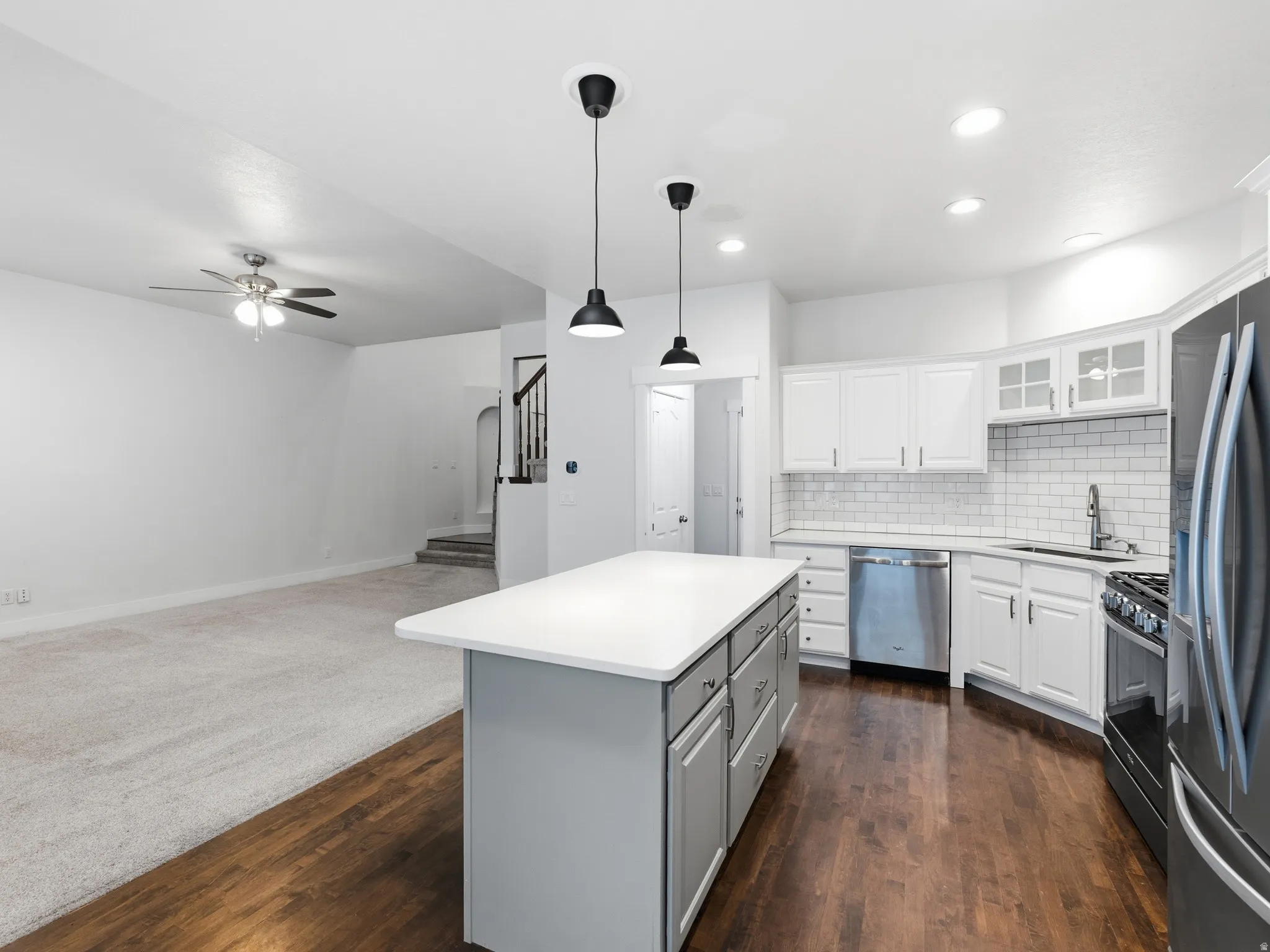 Kitchen with a central island, white cabinetry, subway tile backsplash, and stainless steel appliances