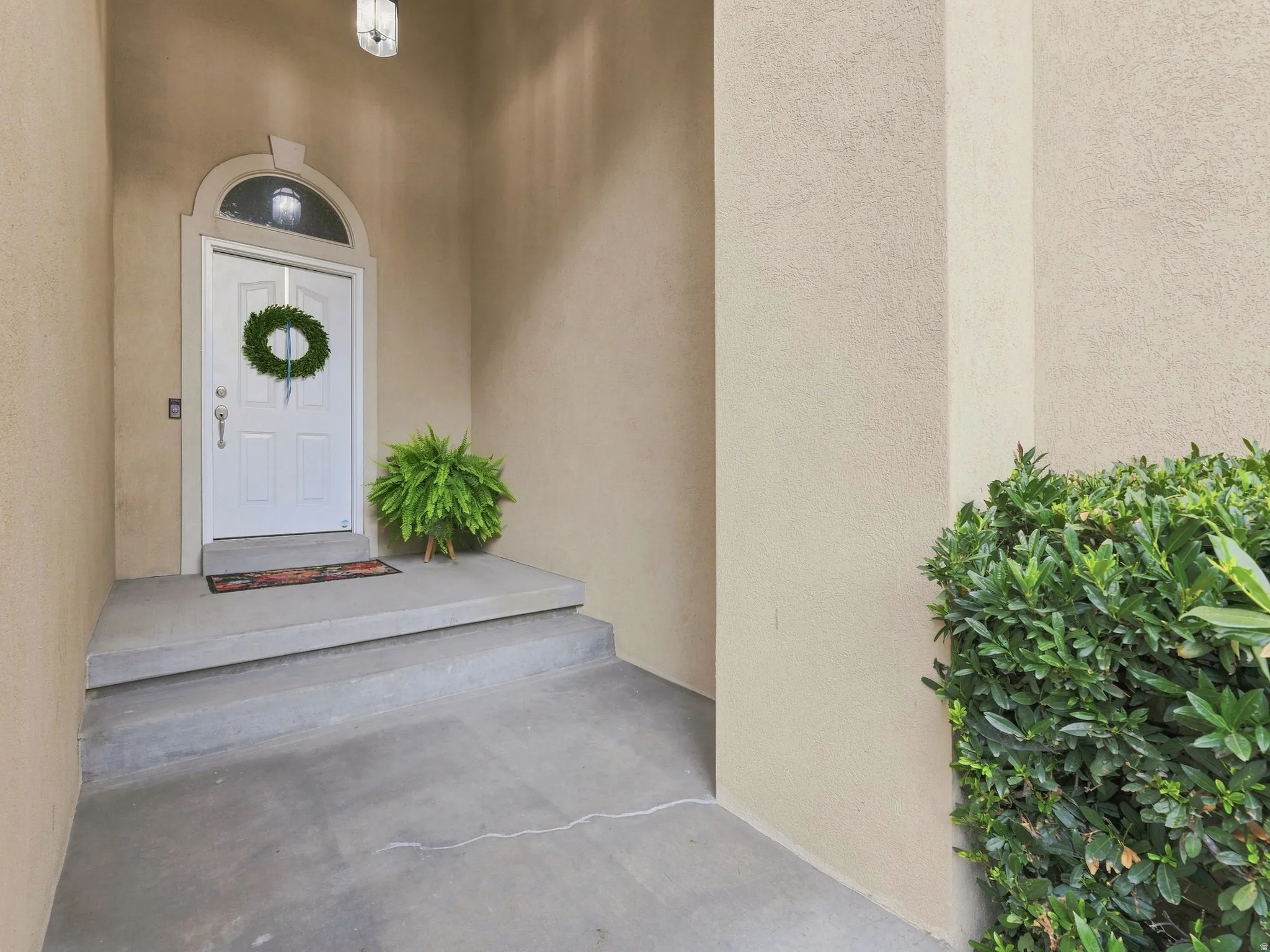 Arched entry door with transom window and concrete steps
