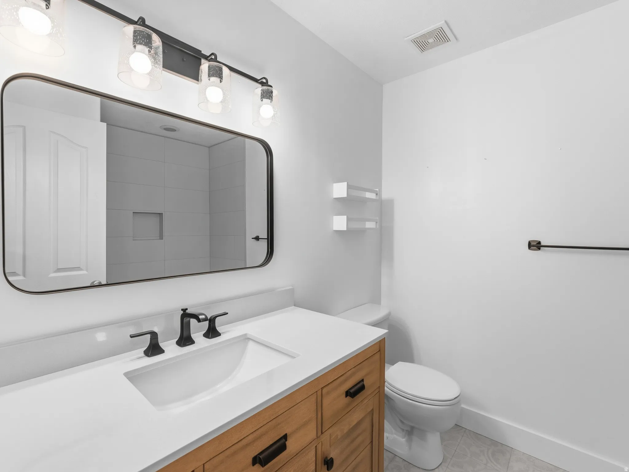 Wood-finish vanity with a white countertop and rectangular sink