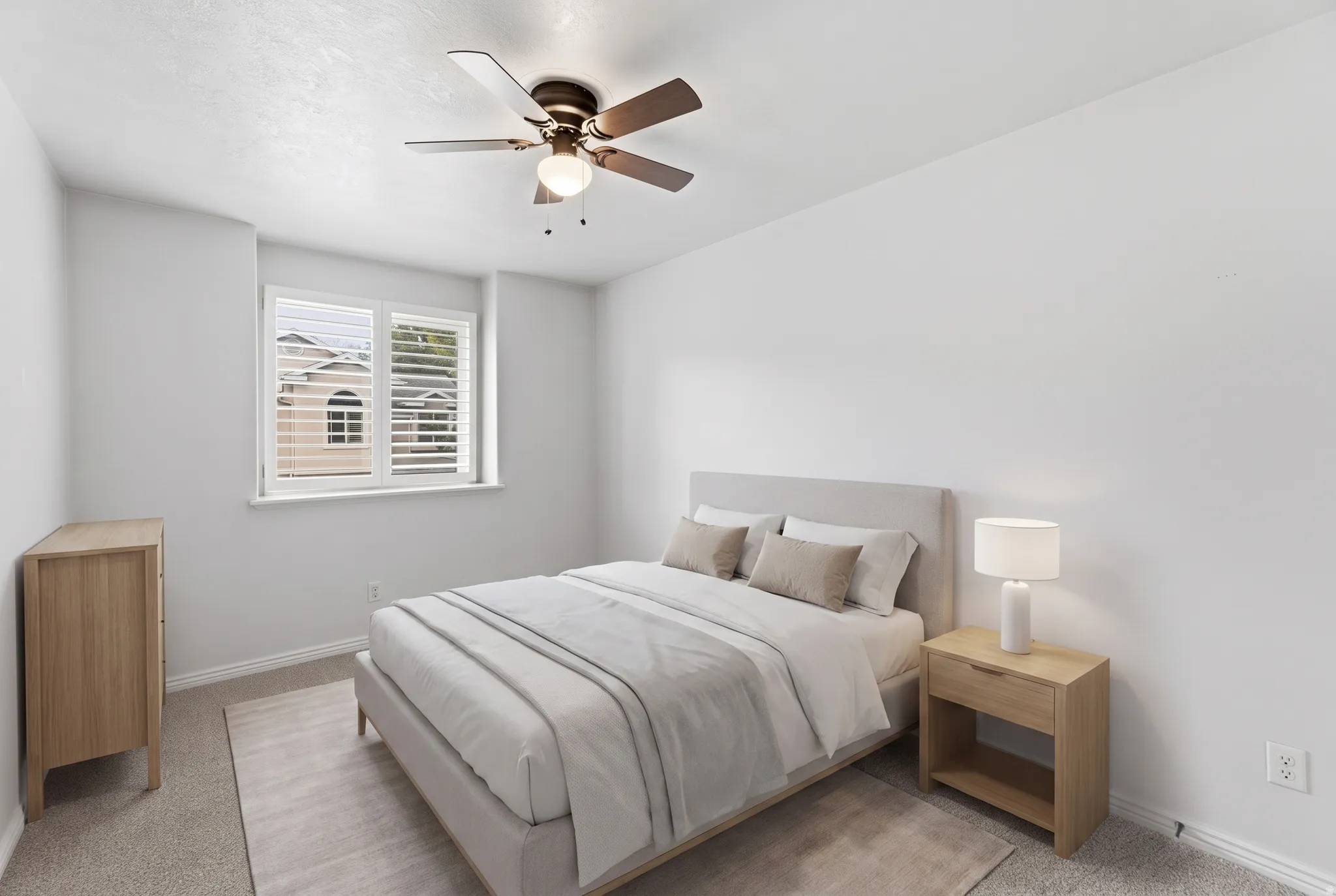 White walls, window with plantation shutters, ceiling fan with integrated lighting, carpeted flooring, and a neutral color palette
