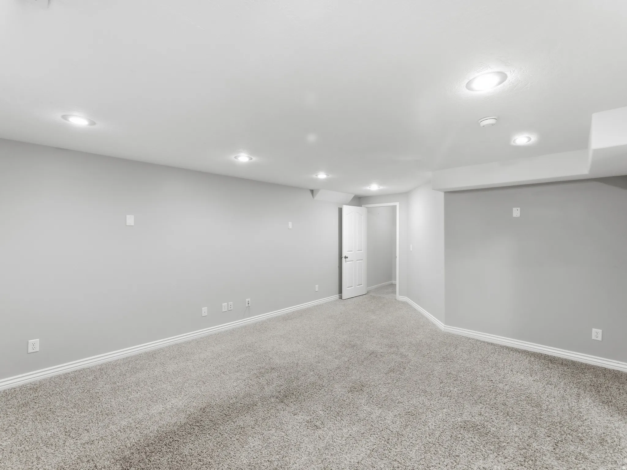 Recessed ceiling lighting, light gray wall paint, and gray carpeting