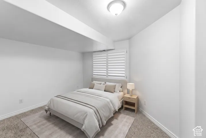Recessed window with white plantation shutters, overhead flush-mount lighting, and neutral-toned wall-to-wall carpeting
