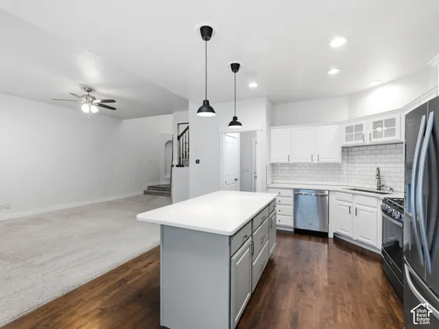 Kitchen with a central island, white cabinetry, subway tile backsplash, and stainless steel appliances