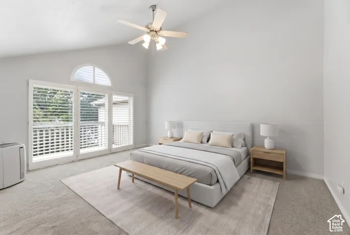 Vaulted ceiling with a ceiling fan, arched transom window, French doors with white shutters, and neutral-toned carpeting