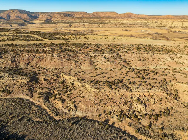 Expansive desert landscape with natural rock formations and scattered low-lying vegetation