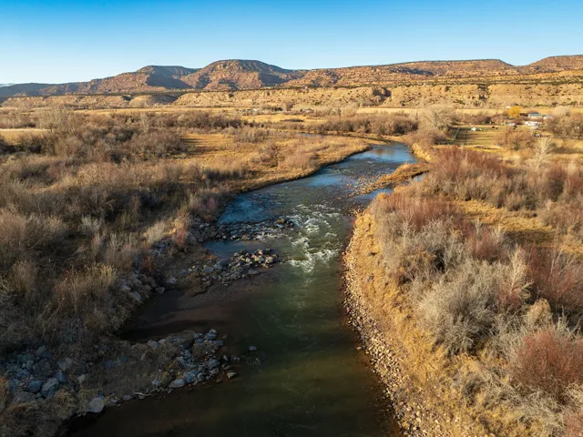 Nearby Duchesne River with a rocky riverbed, surrounded by natural vegetation and distant mountains