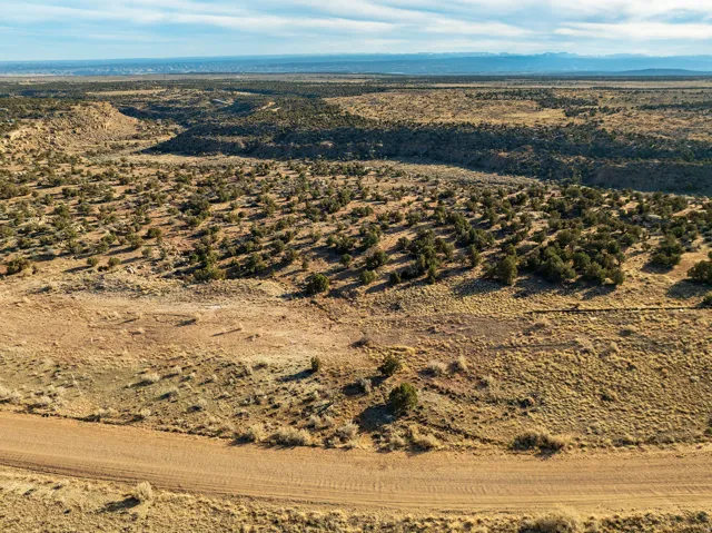 Expansive acreage featuring natural landscaping, a dirt path, and distant mountain ranges