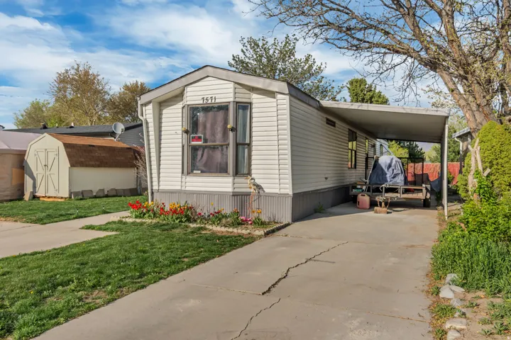 White siding exterior with a carport and concrete driveway