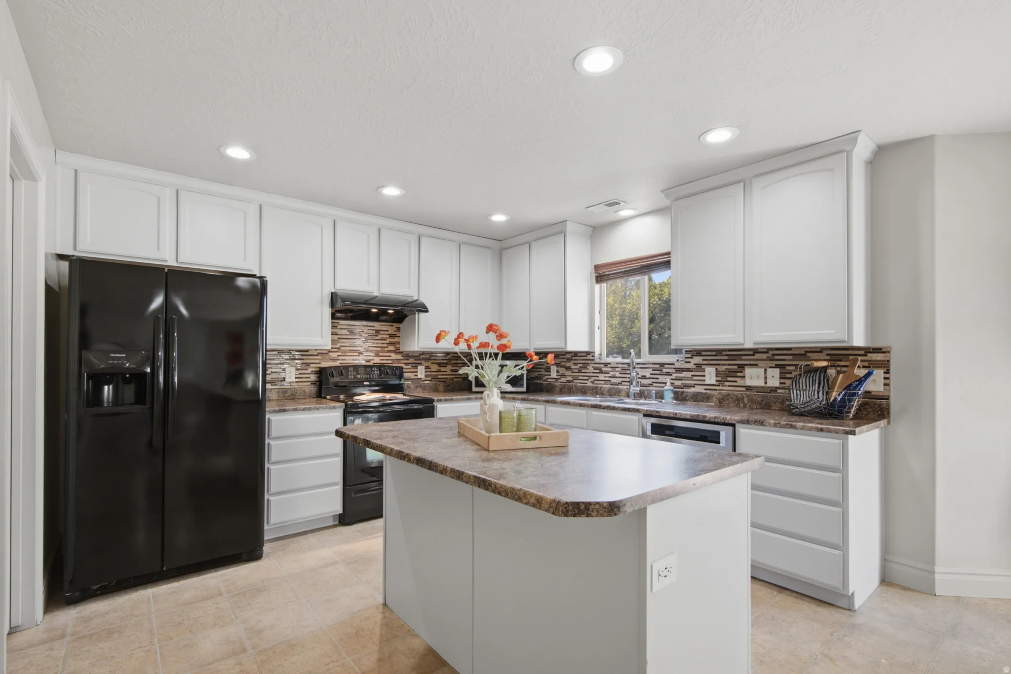 Kitchen featuring white cabinetry, tile flooring, recessed lighting, a center island, and a tile backsplash