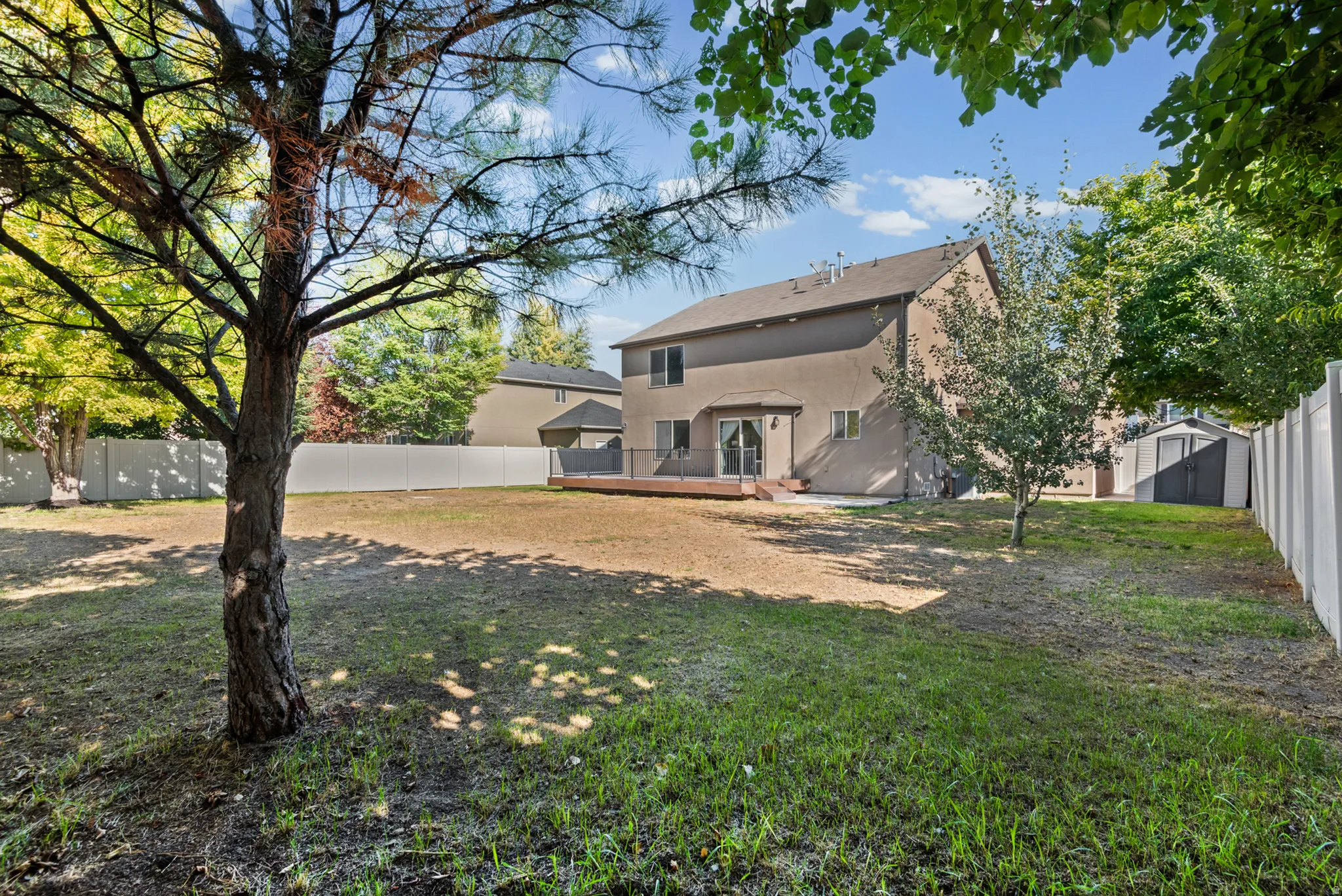 Expansive backyard featuring a wood deck, dual-pane windows, and a privacy fence