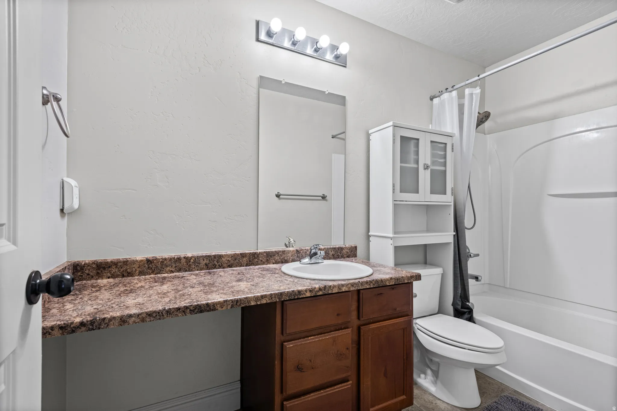 Vanity with an integrated sink, laminate countertop, and wood-finish cabinetry